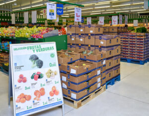 Estante de frutas y verduras en un supermercado Makro con precios visibles.