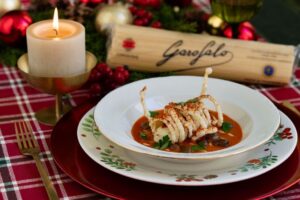 Plato de pasta Garofalo con decoración navideña y vela encendida