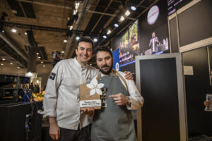 Chefs Jorge Velasco y Joaquín Serrano sosteniendo un premio en Madrid Fusión