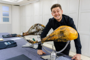 Hombre sonriente junto a jamones ibéricos en una mesa