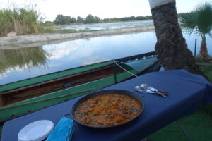 Paella valenciana servida junto a un lago en Albufera de Valencia