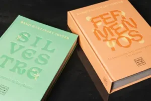 Presentación del libro Fermentos junto a otro libro en una mesa.