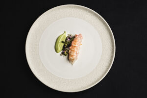 Plato del nuevo menú del Corral de la Morería con mariscos y salsa verde