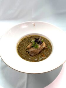 Guiso de lentejas de la Armuña con perdiz en un plato elegante