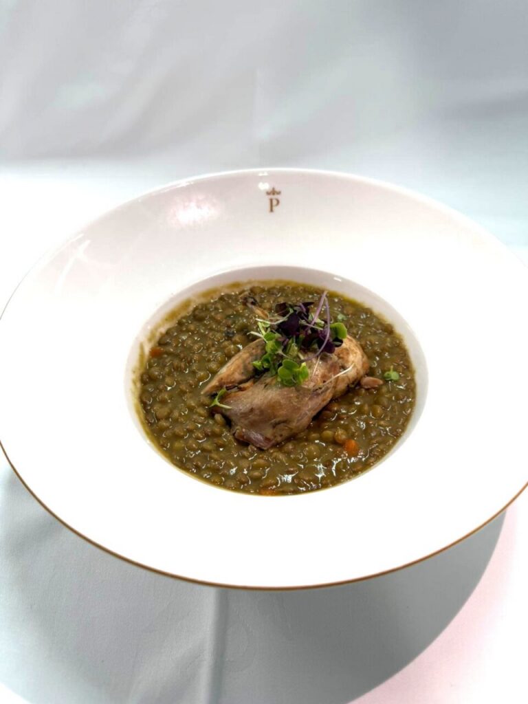Guiso de lentejas de la Armuña con perdiz en un plato elegante