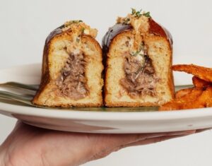 Bocadillo de cordero presentado en un plato con guarnición