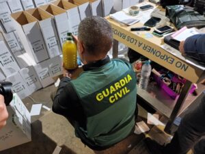 Agente de la Guardia Civil inspeccionando productos en cajas durante una intervención
