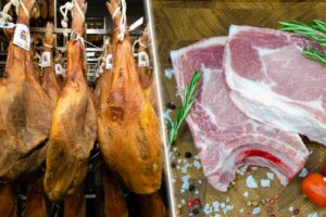 Jamones colgados en secadero y carne de cerdo fresca