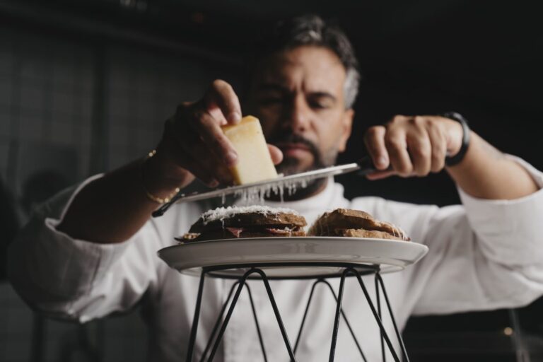 Chef Salvatore Romano preparando un plato con queso rallado