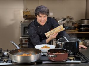 Chef Jordi Cruz sosteniendo espaguetis Garofalo en la cocina