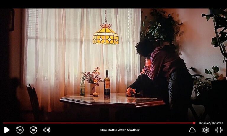 Escena de la película Una Batalla Tras Otra con un vino español en la mesa.