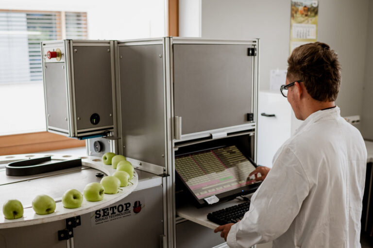 Operador analizando manzanas con tecnología avanzada en Val Venosta