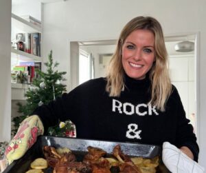 Andrea Ropero sosteniendo una bandeja con Ternasco asado y patatas.