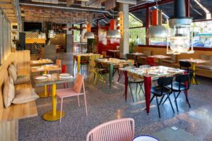 Interior del restaurante Cachivache Montecarmelo con mesas y sillas coloridas