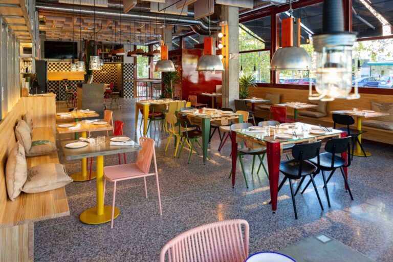 Interior del restaurante Cachivache Montecarmelo con mesas y sillas coloridas