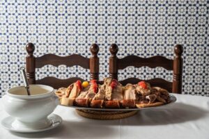 Plato de cocido madrileño servido en La Gran Tasca con carne y legumbres.