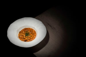 Plato de garbanzos con boletus servido en un tazón blanco