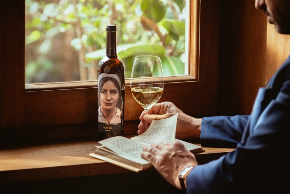 Botella de vino La Moza junto a un vaso y un libro