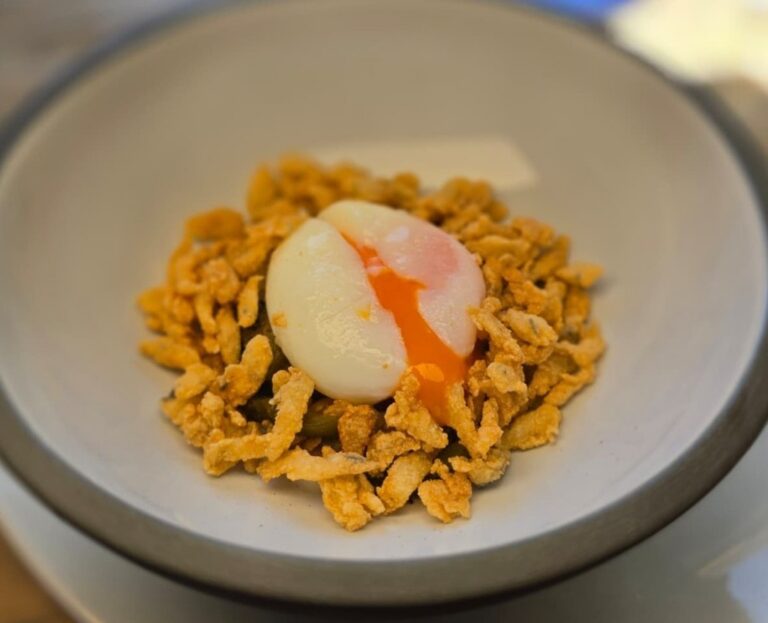 Plato de chanquete frito con huevo poché en un restaurante