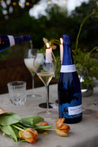 Botella de Mar de Frades Brut con copas y flores en una mesa elegante