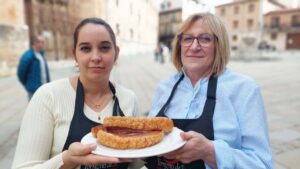 Dos mujeres sosteniendo un torrezno en un plato en Ólvega