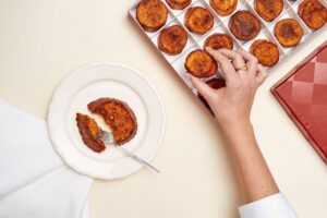 Minitorrijas de Mallorca en una caja con una porción en un plato.