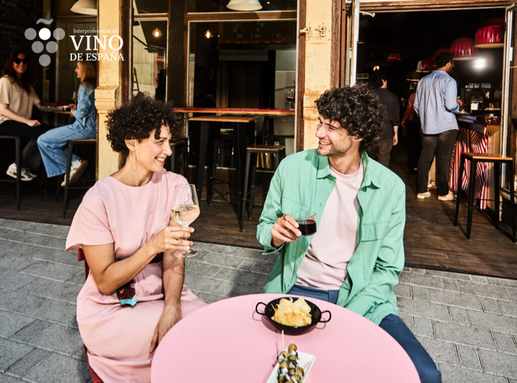 Pareja disfrutando de vino y tapas en un bar moderno