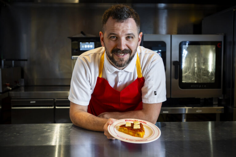 Chef Miguel Carretero sosteniendo un pincho de tortilla en el restaurante Pilla Tortilla.