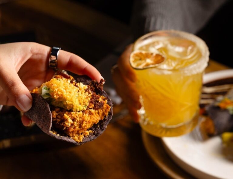 Taco de maíz azul con relleno y bebida en restaurante Bakan