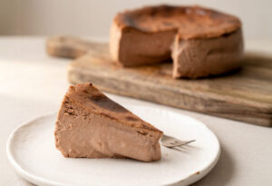 Porción de tarta de queso con chocolate belga en un plato blanco