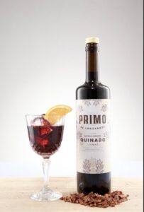 Botella de vermut Quinado Primo de Lanzarote con copa y rodaja de naranja