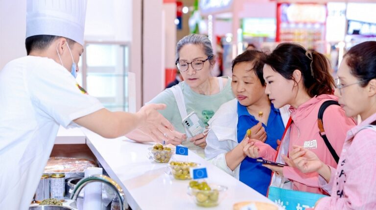Chef presenta aceitunas españolas a un grupo de personas en un evento