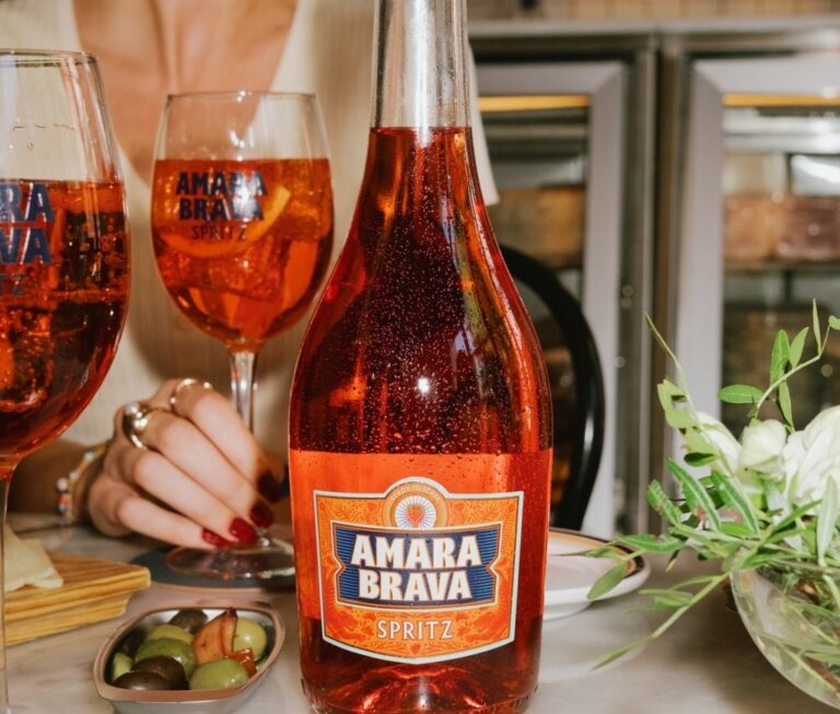 Botella de Amara Brava Spritz junto a copas y aperitivos
