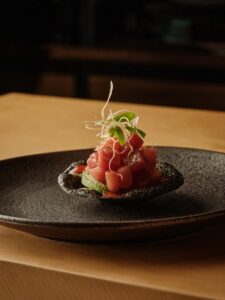 Plato gourmet en Amaterasu, Hotaru Madrid, con ingredientes frescos y presentación elegante.
