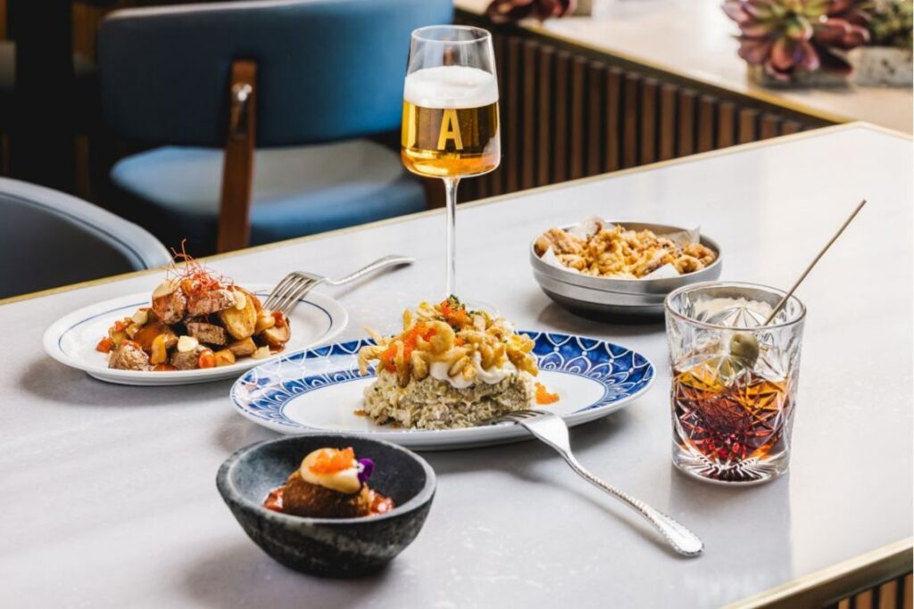 Plato de aperitivos con bebida en Barra Alta, Madrid.