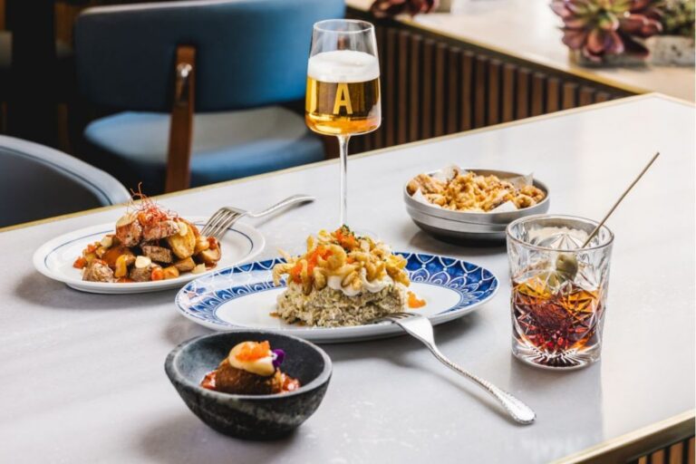 Plato de aperitivos con bebida en Barra Alta, Madrid.