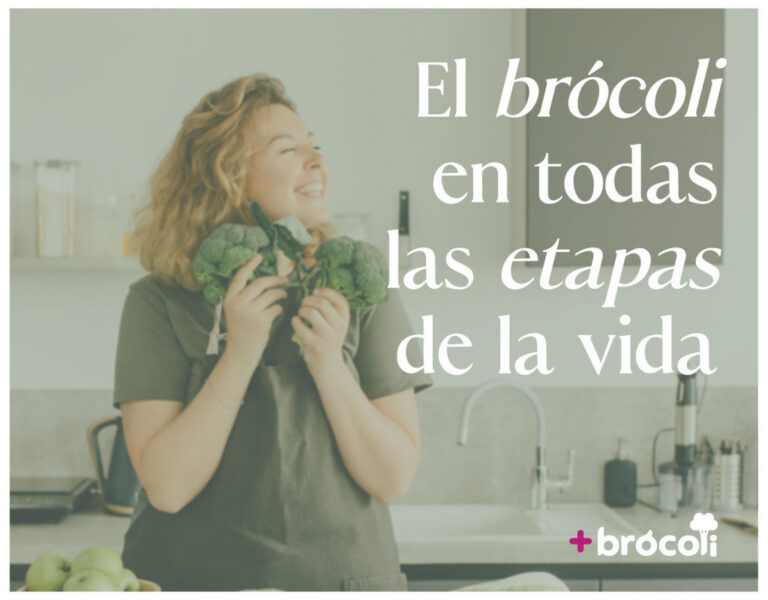 Mujer sonriente sosteniendo brócoli en la cocina