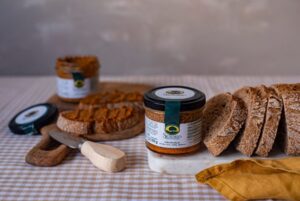 Tarro de cachuela de bellota sobre una mesa con pan tostado