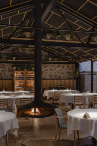 Interior del restaurante Caleña con mesas y chimenea moderna.