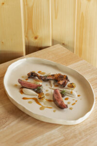 Plato gourmet del restaurante Caleña en Ávila con carne y salsas.