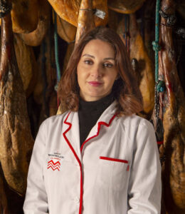 Carmen Curto en la fábrica de Ibéricos Montellano rodeada de jamones