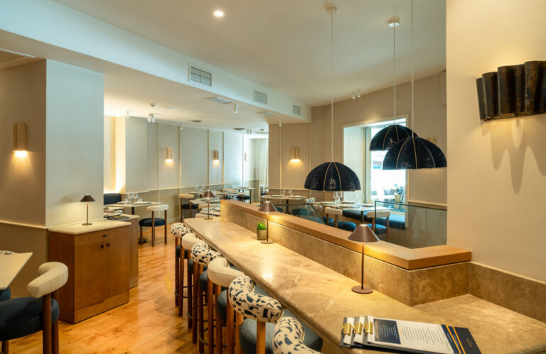 Interior renovado del restaurante Cinco Jotas en Madrid con mesas y decoración moderna.