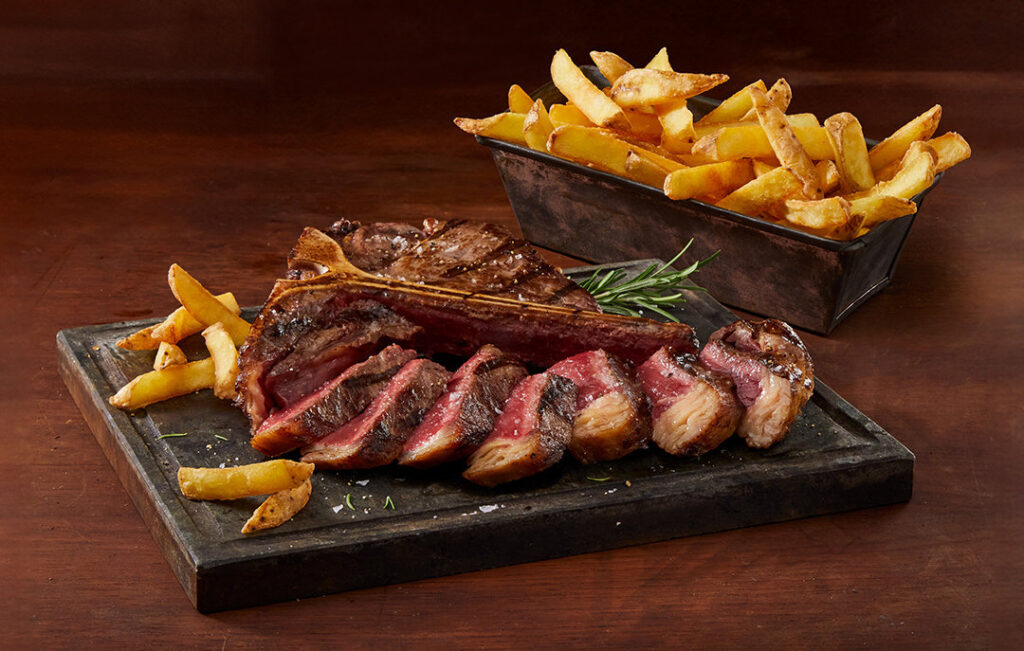 Plato con carne asada y patatas fritas crujientes