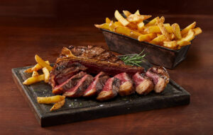Plato con carne asada y patatas fritas crujientes