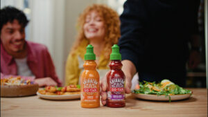 Botellas de salsa Sriracha Go-Tan en una mesa con comida