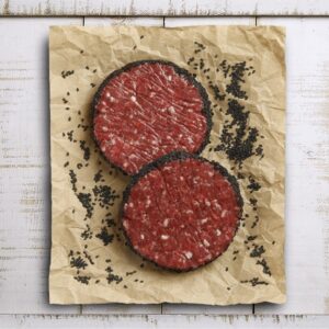 Dos hamburguesas de carne cruda sobre papel arrugado