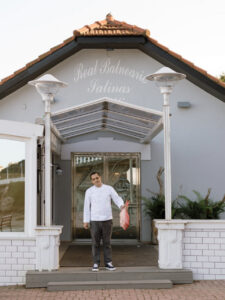 Chef Isaac Loya sosteniendo un pescado frente al Real Balneario de Salinas