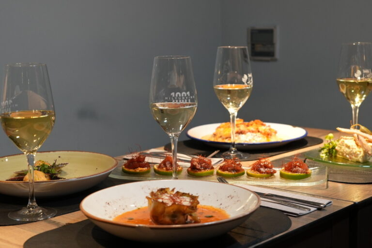 Mesa con platos gourmet y copas de vino en DisTinto Taberna