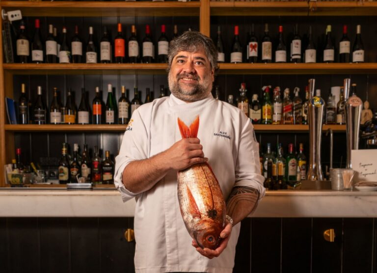 Chef Alex Santamaría sosteniendo un besugo en su restaurante Infame.