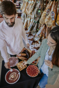 Pareja degustando productos ibéricos en una tienda de Extremadura